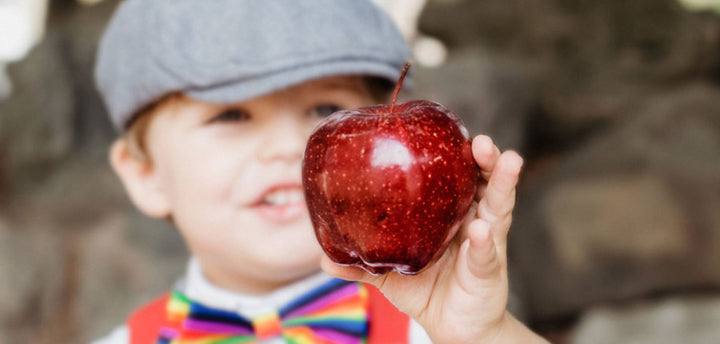 Boy holding a red apple