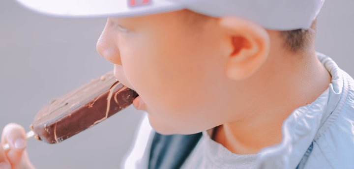 Boy eating chocolate covered ice cream