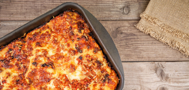 Baked lasagna in a pan on a wooden table