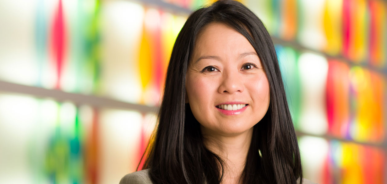 Headshot of Dr. Julie Wei against a colorful background