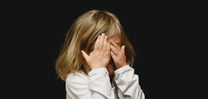 Little girl covering her face
