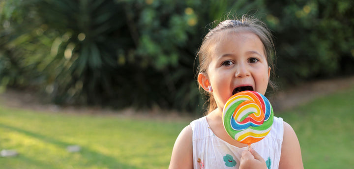 Girl eating a large lollipop