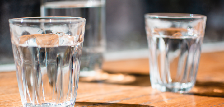 Two glasses of water on a wooden table
