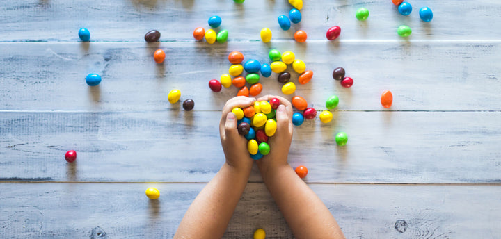 Kids' hands holding pieces of candy