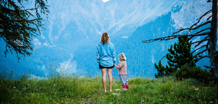 A mother and daughter standing on a mountain