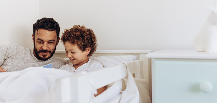 Father reading to son while in bed