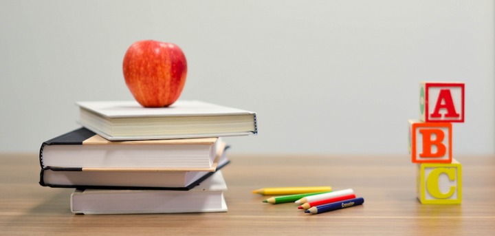 Books, blocks and an apple on a table