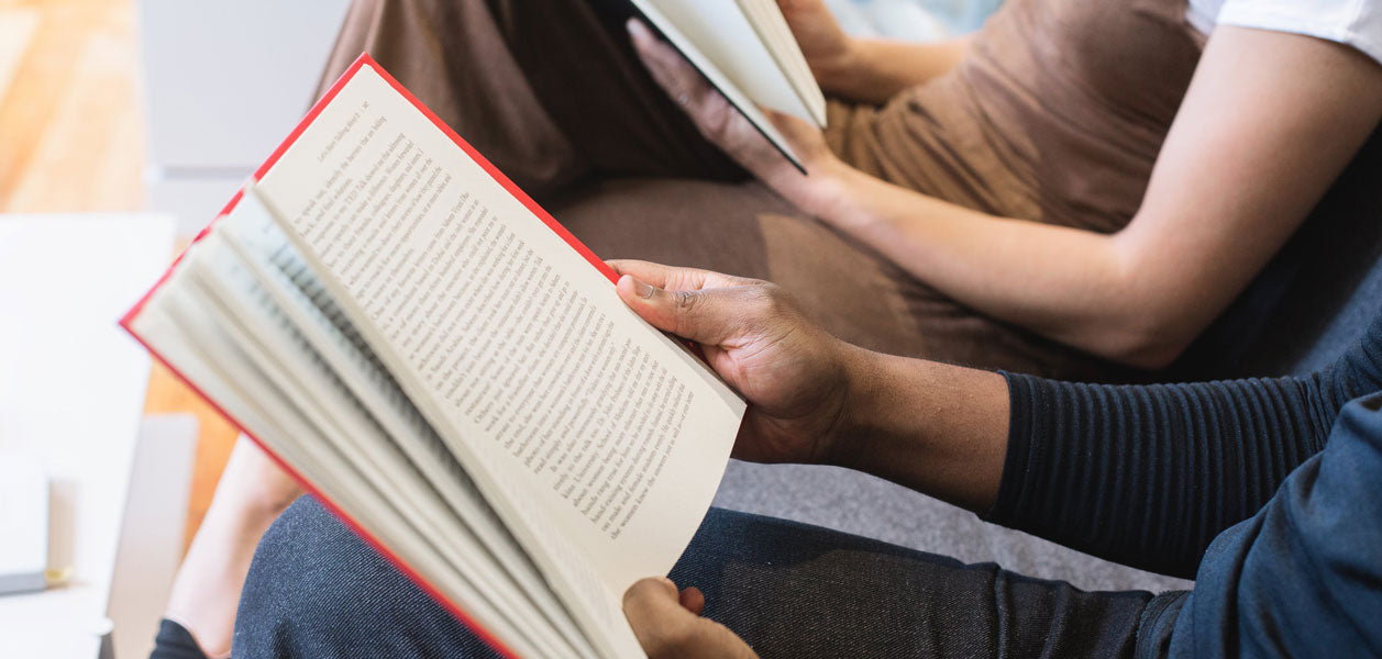 Close up of two people reading books