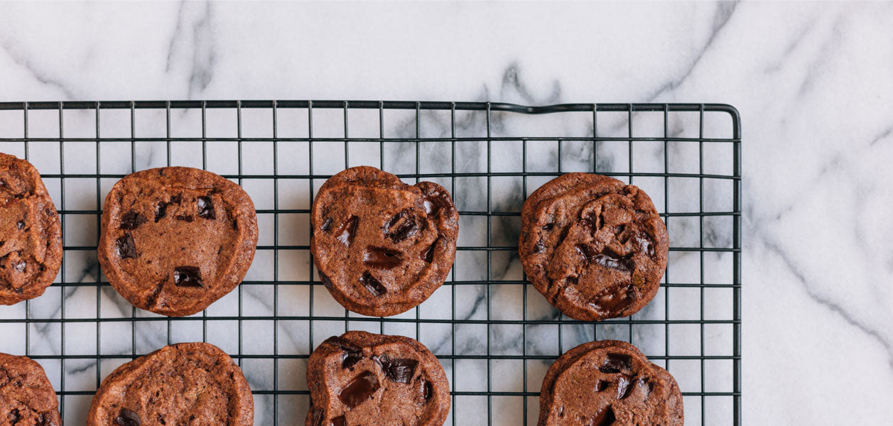 Chocolate chip cookies on a metal tray places on a marble counter