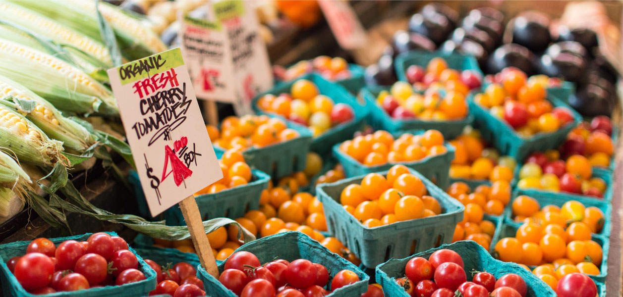 Table of fresh red and yellow cherry tomatoes for sale at a market